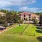 a large building with a lawn and trees in front of it