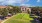 a large building with a lawn and trees in front of it